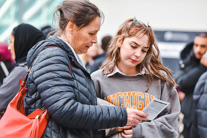 A parent looking at a card with their child in the Atrium