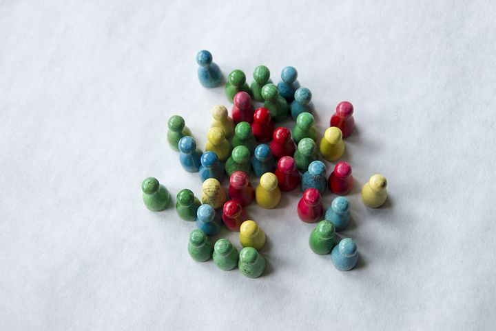 Boardgame pieces representing people clustered together.