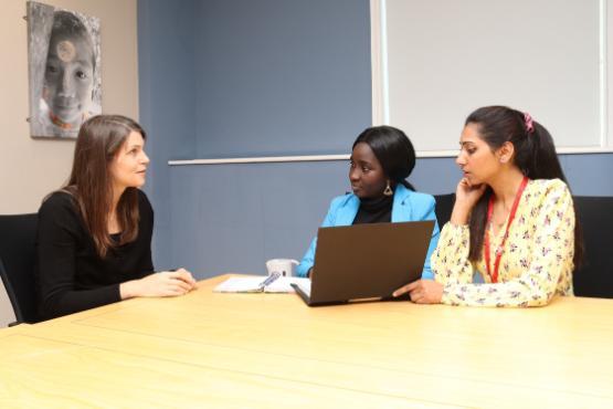 Students sitting around a table interviewing a client