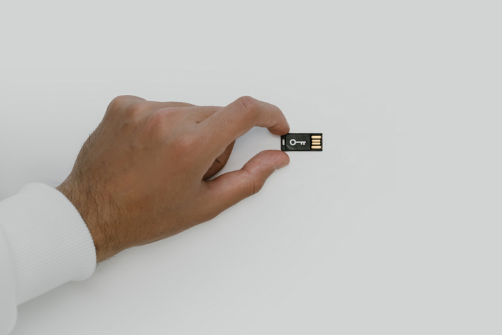 Hand holding a small USB card.