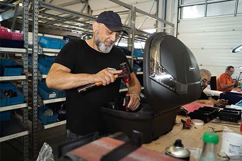 Man working in a small company fixing an electrical appliance 