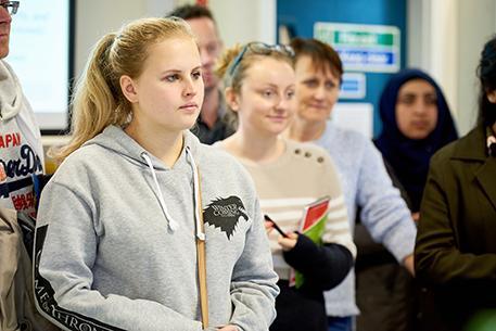 A landscape shot of a female listening to a talk
