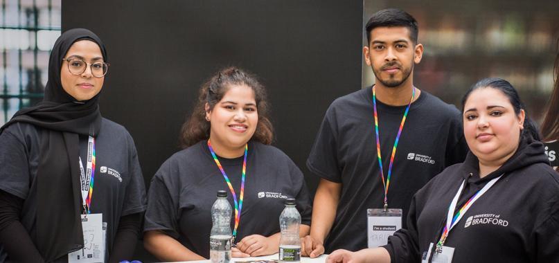 Four student ambassadors at an on-campus open day stand