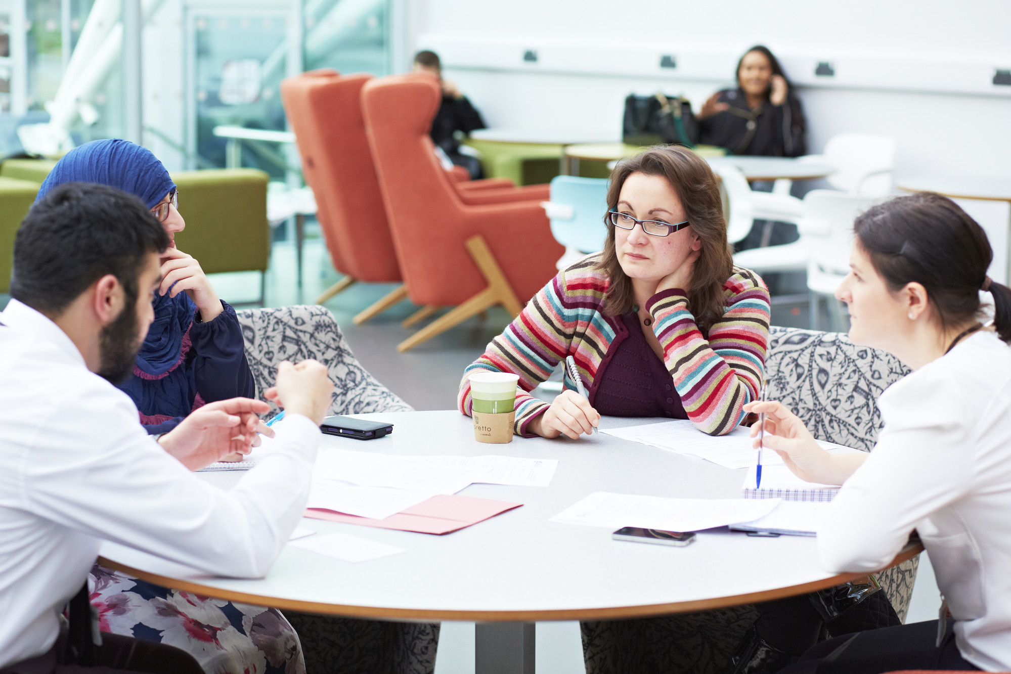 A group of students sat around a table in The Atrium building.