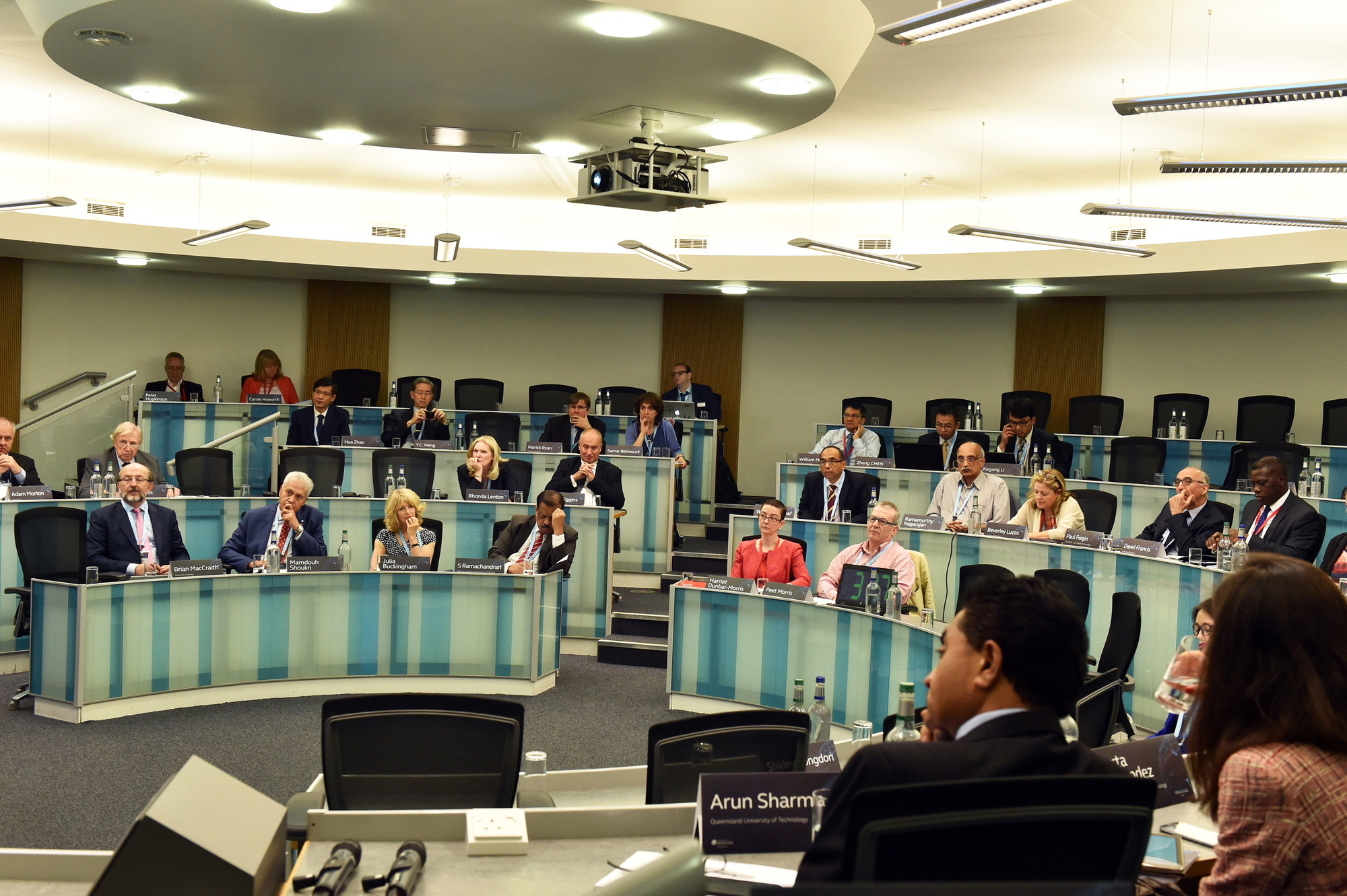 A person leading a conference to lots of attendees who are seated.