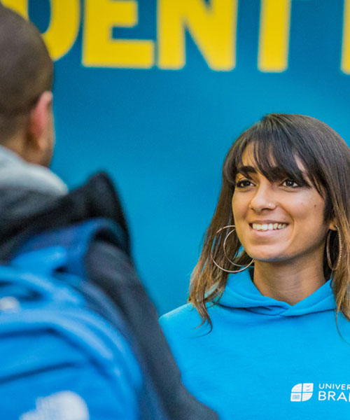 A student ambassador smiling and chatting to open day guests.