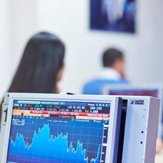 A computer with a graph of financial data on the screen.