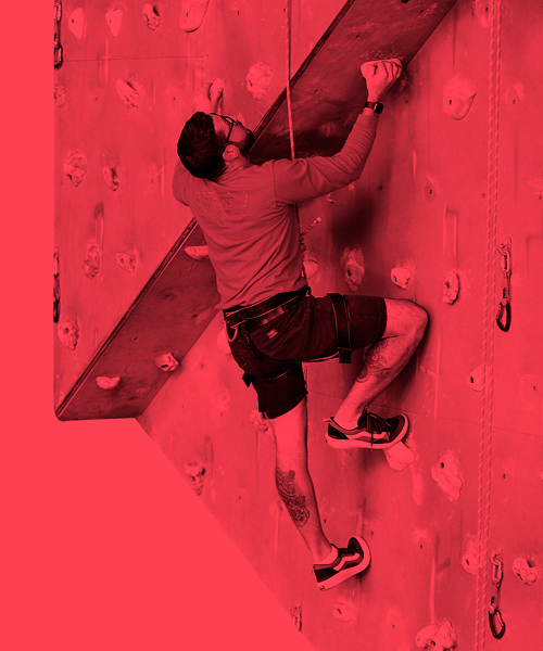 Man climbing on a roped climbing wall. 
